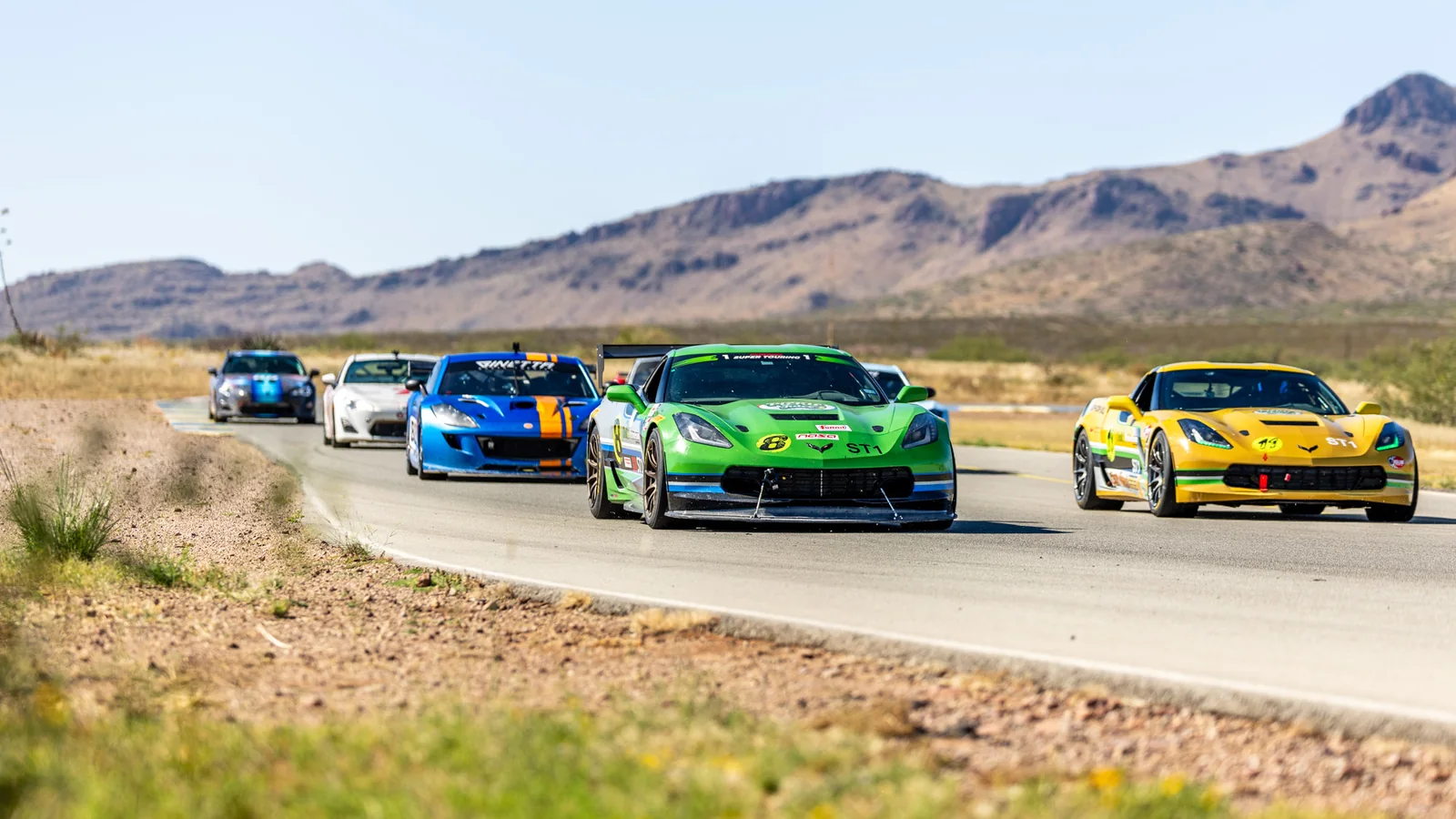 Green and yellow Corvettes leading the IMR Challenge Series field